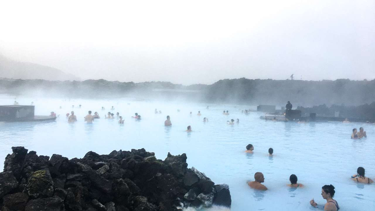 People in a pool with steam coming off of it