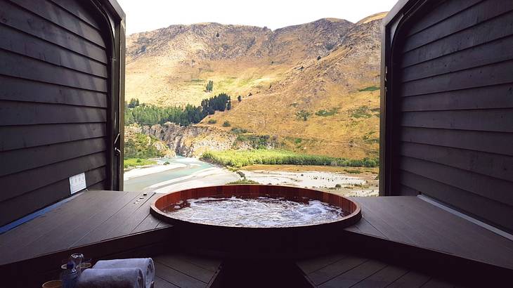 A circular pool nestled within a wooden facility with overlooking view of a mountain