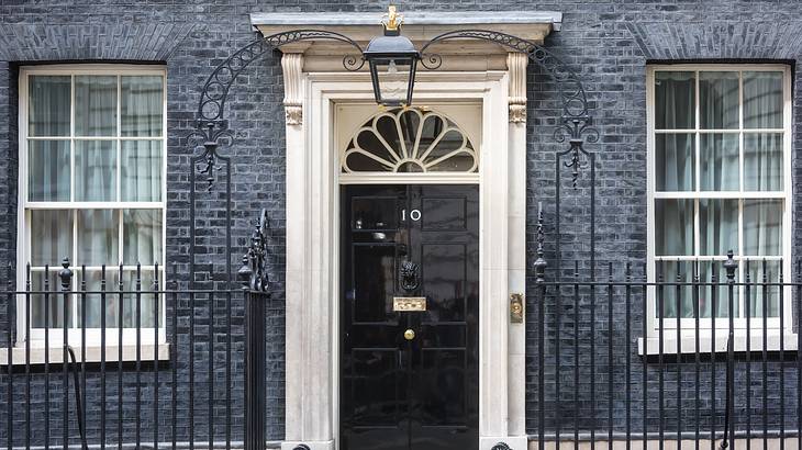 A black brick building with a black door with a number 10 and a stone surround