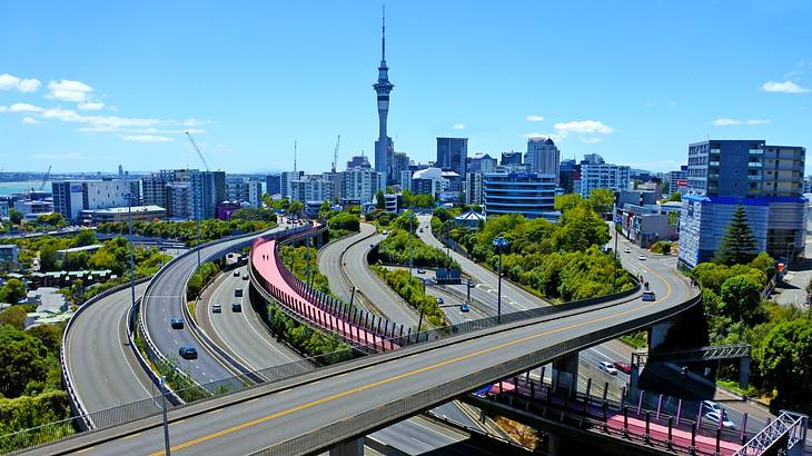 Highways with a tall tower and skyscrapers in the background