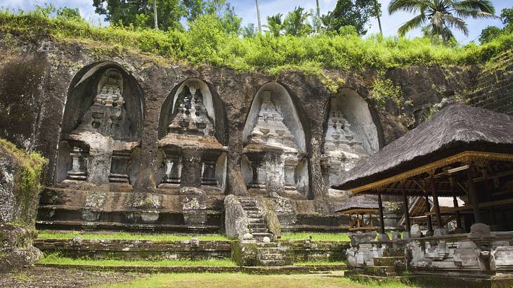 An ancient temple with carvings in rock and greenery