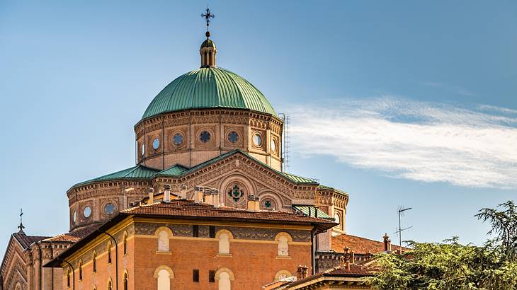 A church with a green dome-like top with a cross