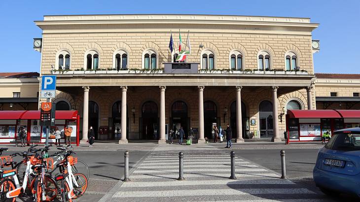 A pedestrian lane leading to a white building with an Italian flag