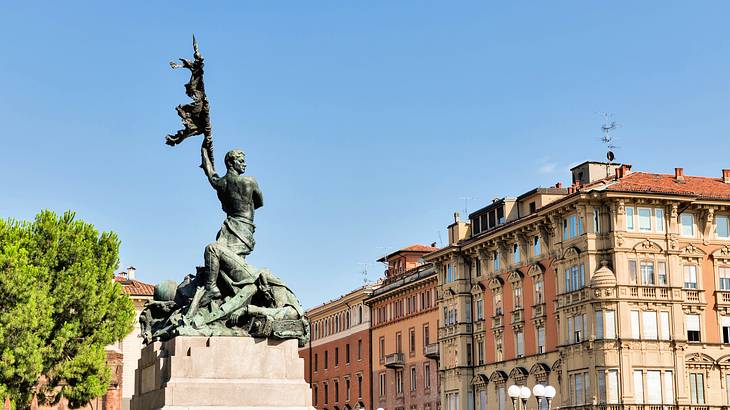 A sculpture of a man raising a flag with old buildings in the background