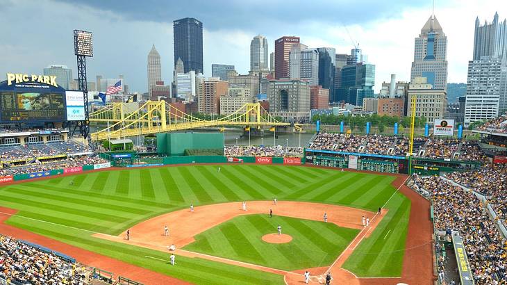 A baseball stadium with a city skyline behind it