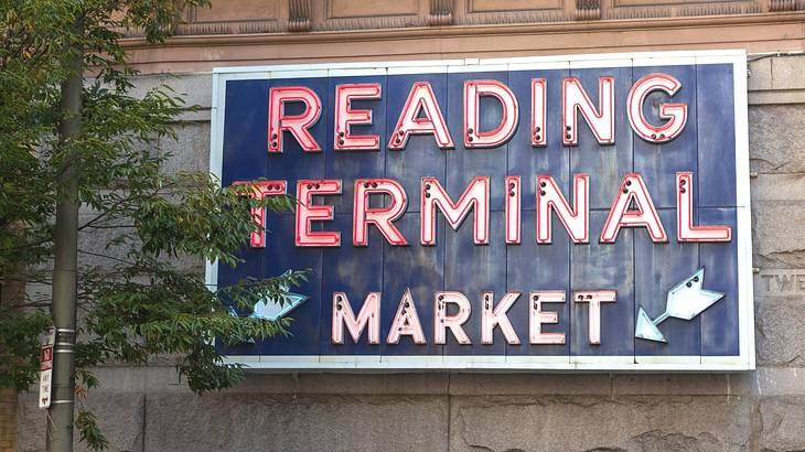 A sign that says "Redding Terminal Market" with a tree to the left of it