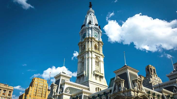 A tall stone tower surrounded by other rooftops, under a blue sky