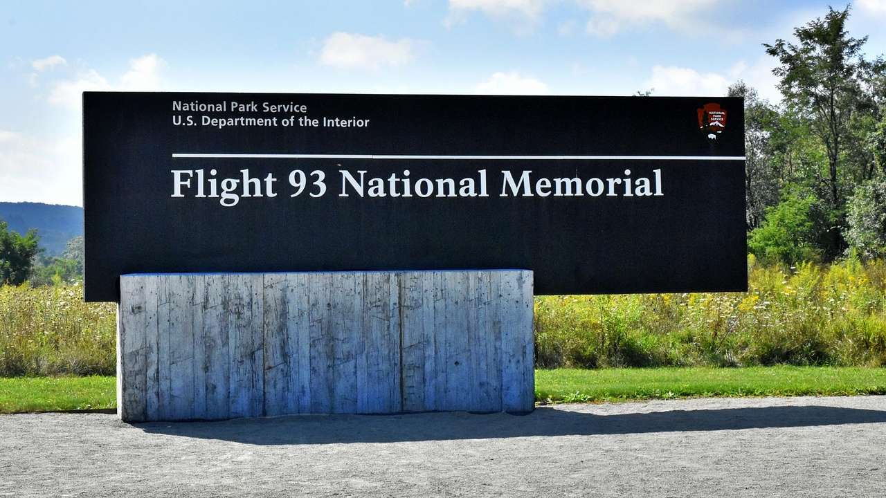 A sign in a park that says "Flight 93 National Memorial" with greenery behind it