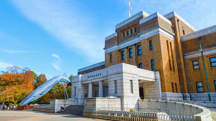 Side view of a bricked building with a life-size model of a whale at the entrance