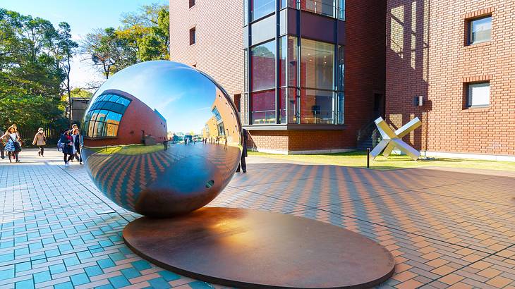 Silver sphere on a platform with modern structures and buildings around