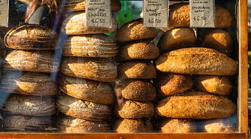 Stacks of bread in a window display, with price tags at the top, at a market