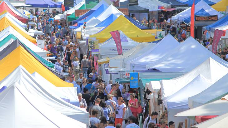 Busy market stalls lined with people from above