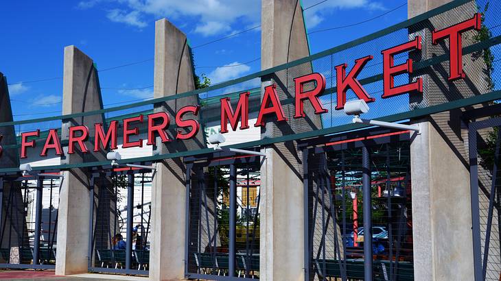 A wide gate with a red sign saying "Farmers Market"