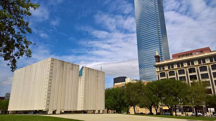 An art installation made of concrete columns near trees and buildings