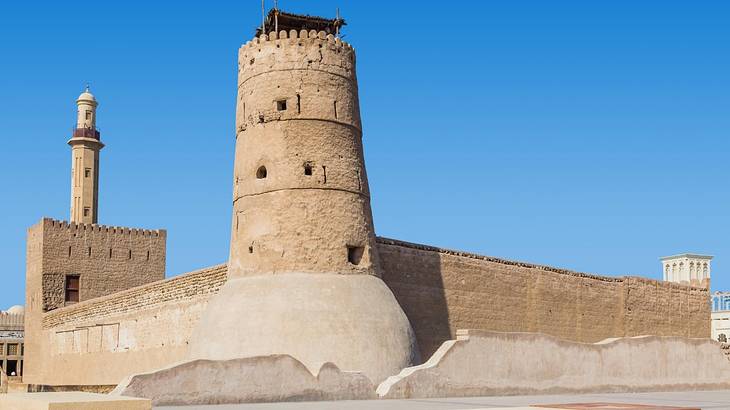 An old-fashioned stone fort structure under a clear blue sky