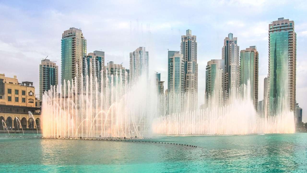 A dancing water display in front of tall modern buildings