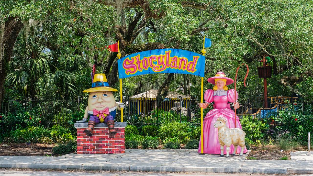 Statues of two cartoon characters holding a signboard that reads "Storyland"