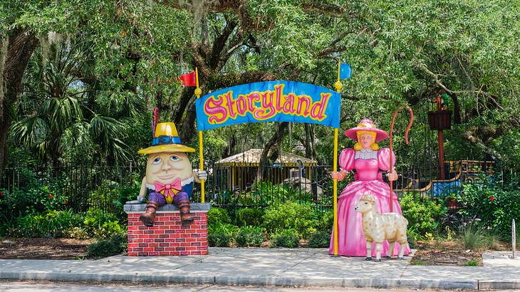 Statues of two cartoon characters holding a signboard that reads "Storyland"