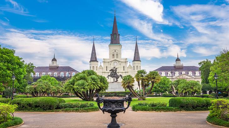 A white and black cathedral with a green park in front under a blue sky