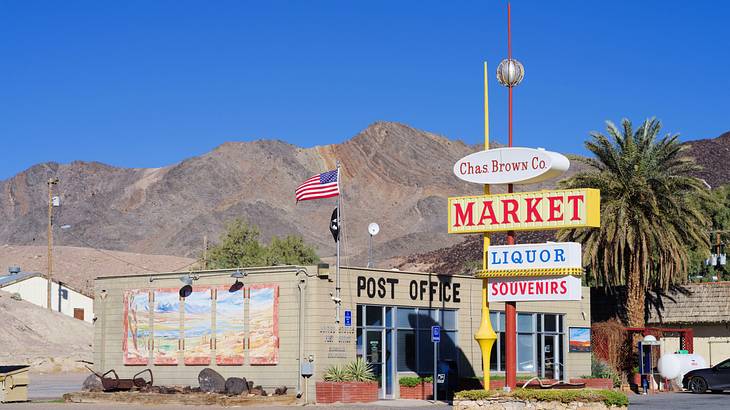 An establishment sign near a structure with a hanging American flag on its top