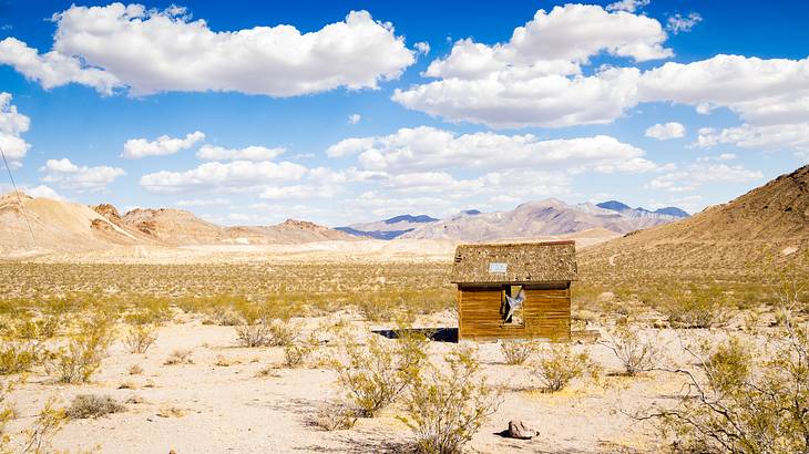 An old abandoned house in the middle of a desert on a cloudy day