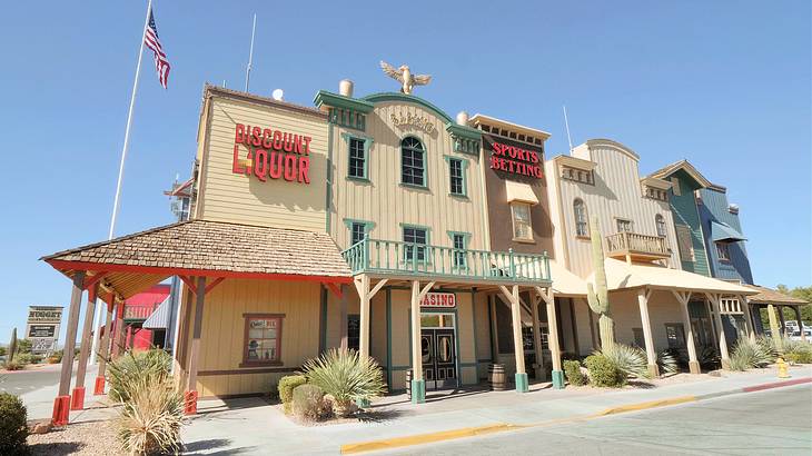 Old Western structures near a flagpole with an American flag