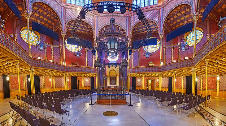 The interior of a room with a colorful dome ceiling and chairs on the stone floor