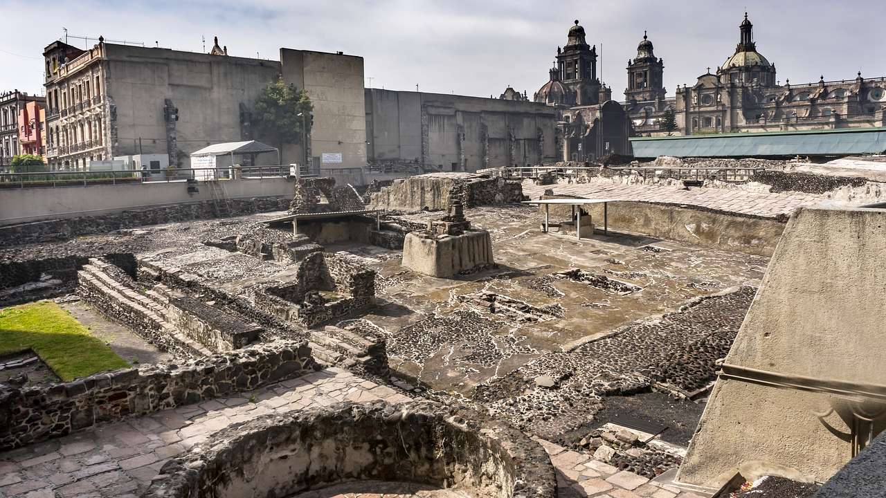 Ancient ruins with staircases and buildings in the background