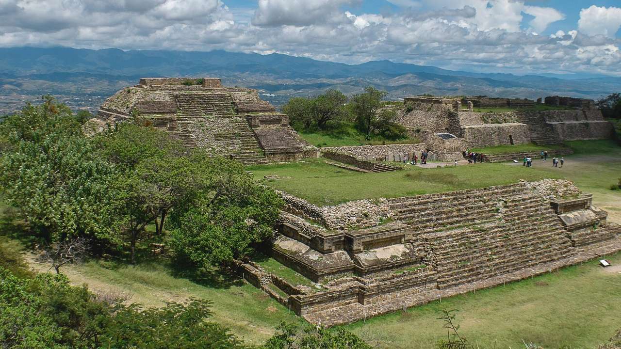 A pyramid-like plateau with stairs & another pyramid structure surrounded by trees