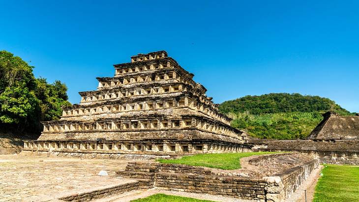 A pyramid with each side covered in stacked rows of small niches under a clear sky A pyramid with each side covered in stacked rows of small niches under a clear sky