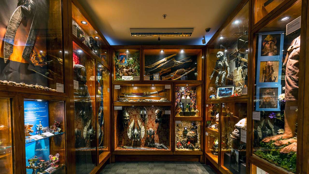 A room with an array of items displayed behind glass with overhead lighting