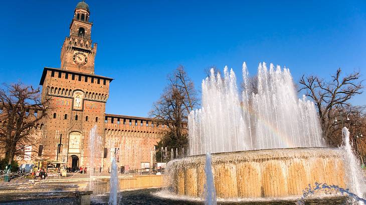 Water spraying out of a fountain in front of the Sforzesco Castle