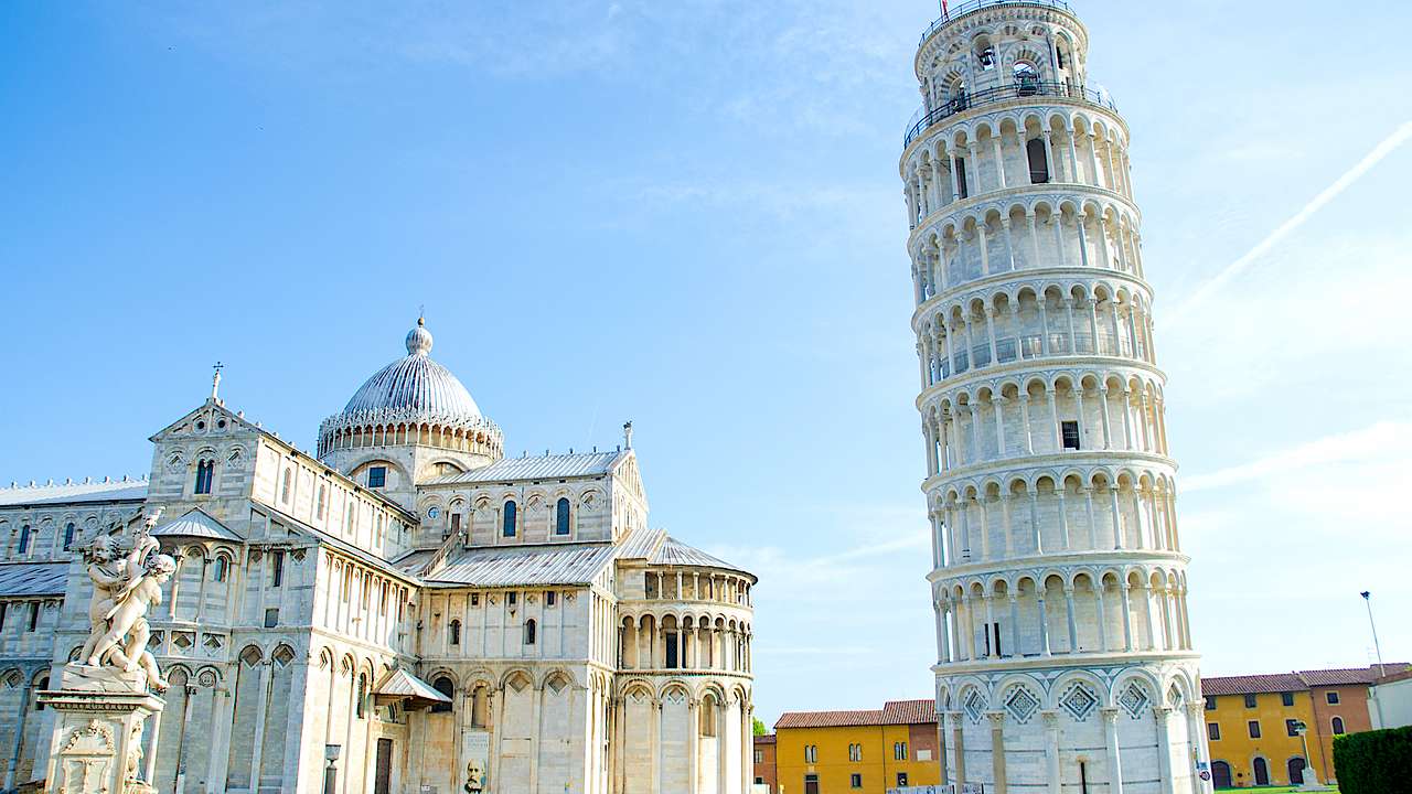 Leaning Tower of Pisa beside the Pisa Cathedral under sunny blue skies