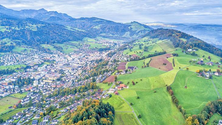 An aerial shot of a village on a mountain under a cloudy sky