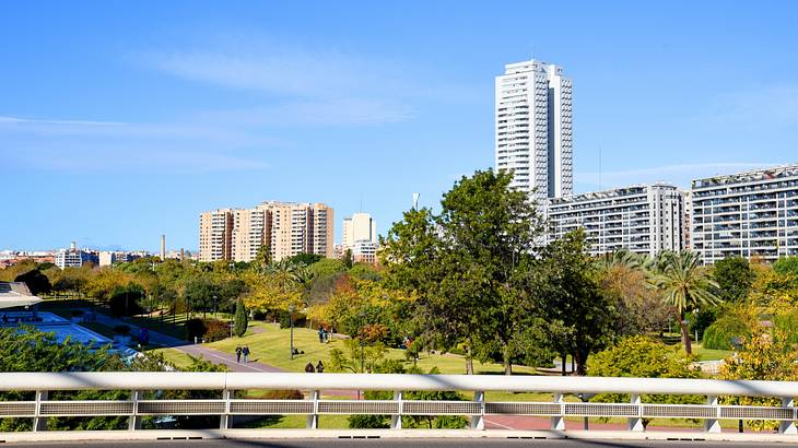 A bridge with a view of a landscaped park near skyscrapers