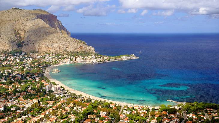 Aerial shot of a village near a mountain and the sea