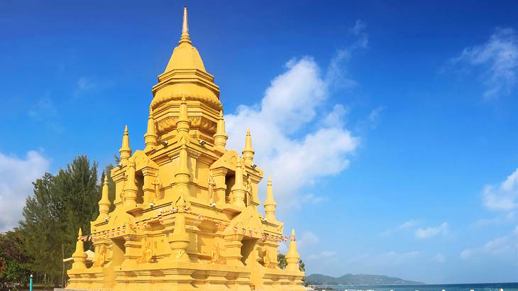 A golden pagoda near a tree and the sea