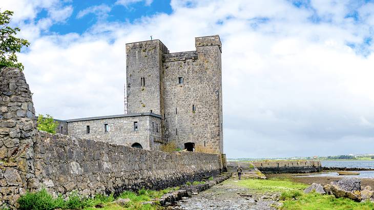 A low-angle shot of an old stone castle near a body of water