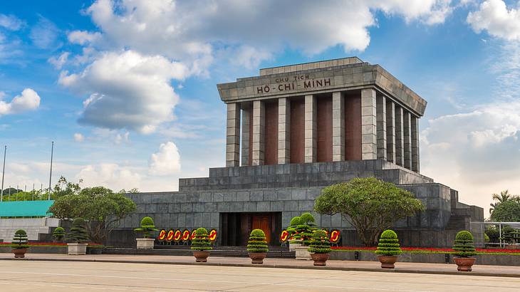 A stone building with columns and a "Ho Chi Minh" sign atop a stone foundation