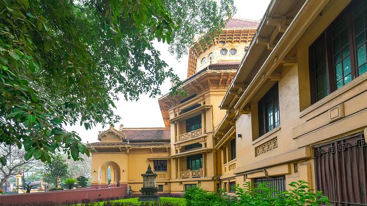 A historic building with greenery and a walkway in front