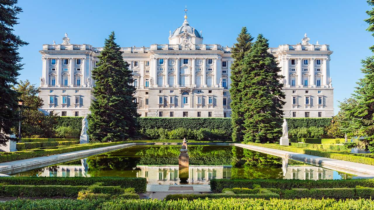 A Baroque-style building with a landscaped garden in front