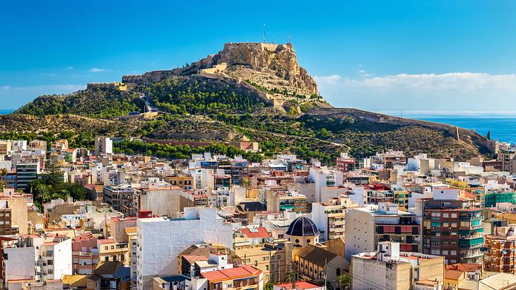 Colorful buildings near a mountain with an old castle on top