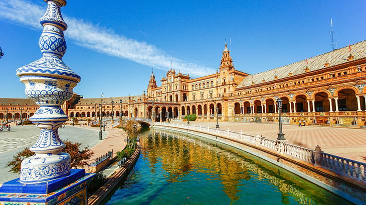 An expansive Spanish Renaissance-style building with an artificial waterway in front