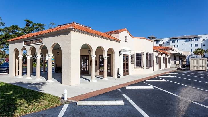 A white structure with arches and an orange roof with a "Naples" sign