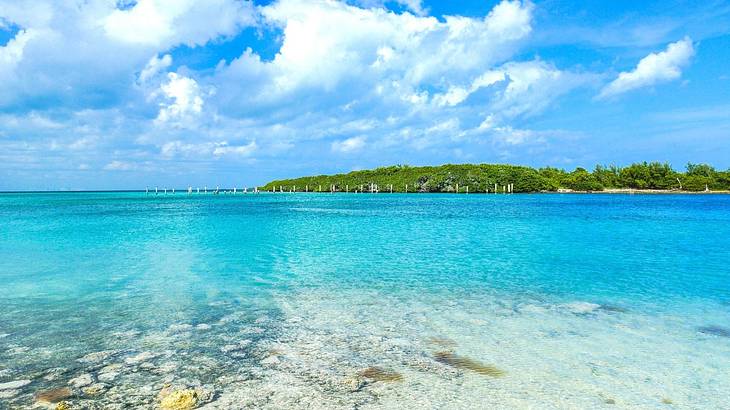 Clear turquoise water with a greenery-covered island in the distance