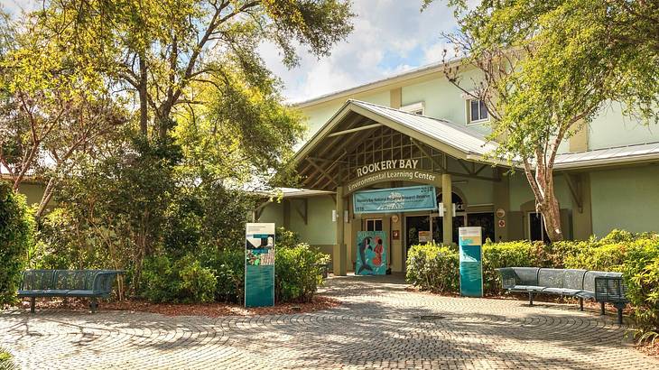 A building with a "Rookery Bay" sign and trees and a path in front of it