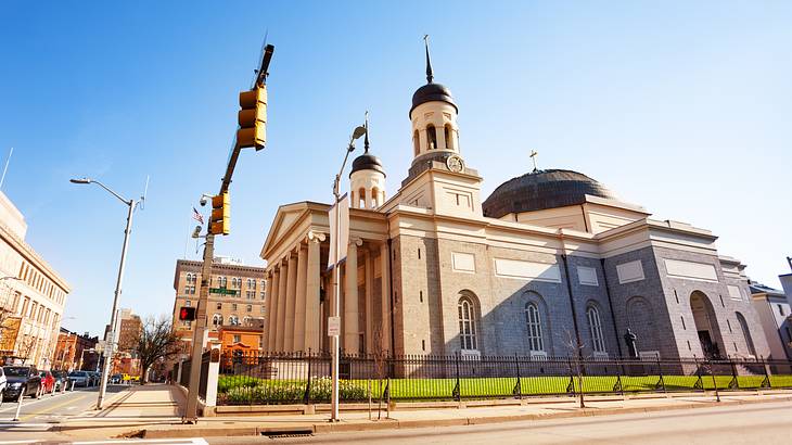 A Neoclassical-style cathedral next to a street on a sunny day