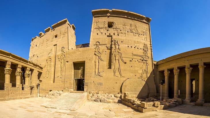 Carvings of ancient people on the Temple of Philae's entrance