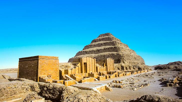 View of a pyramid and ancient ruins against a blue sky
