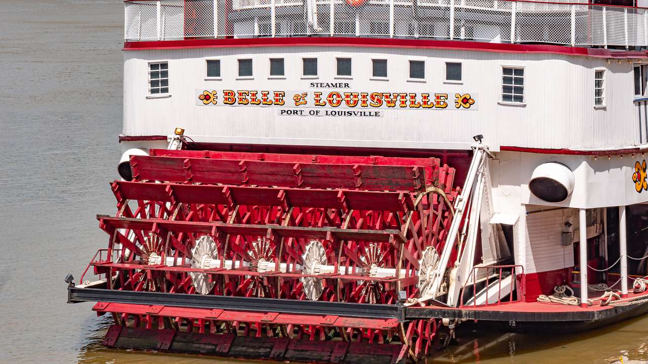 A red and white paddle boat with a "Belle of Louisville" sign